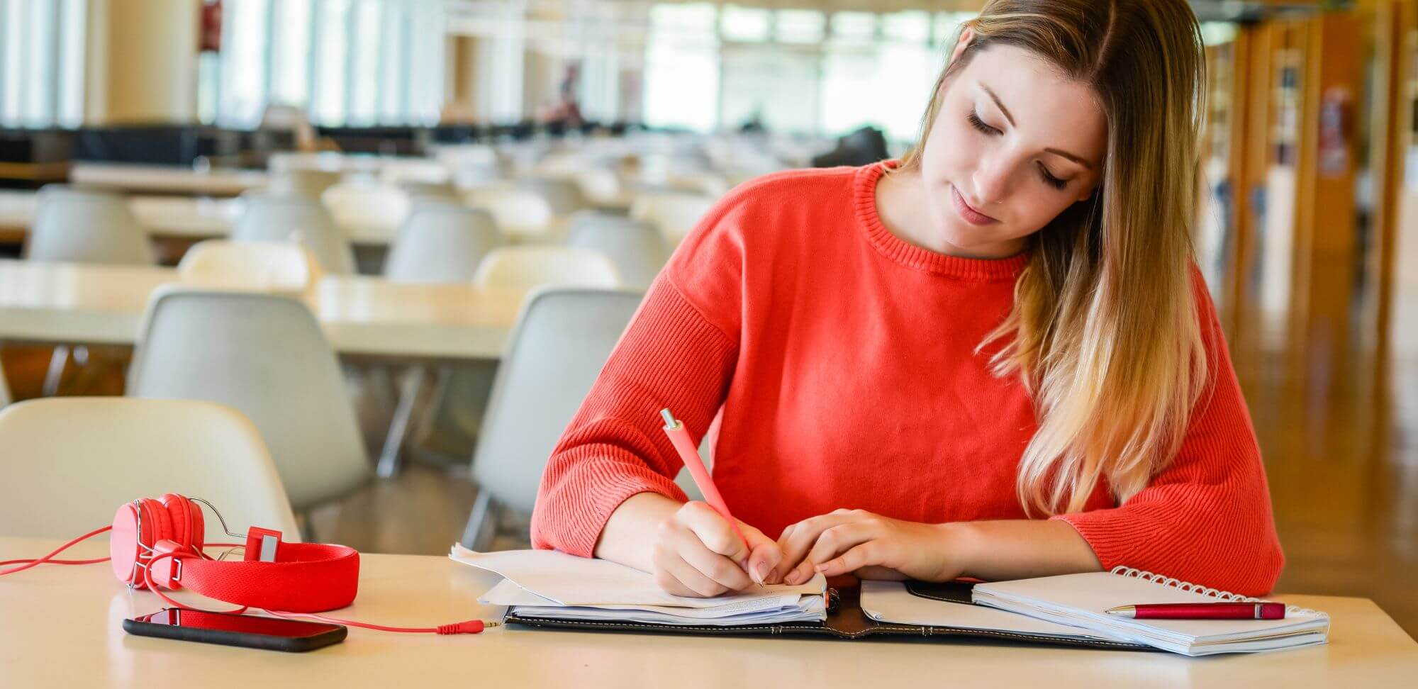 Indicadores de qualidade do MEC: fotografia de uma estudante escrevendo em um caderno.