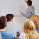 Índice Geral de Cursos: fotografia de uma sala de aula. à frente, um professor escreve em um quadro branco.