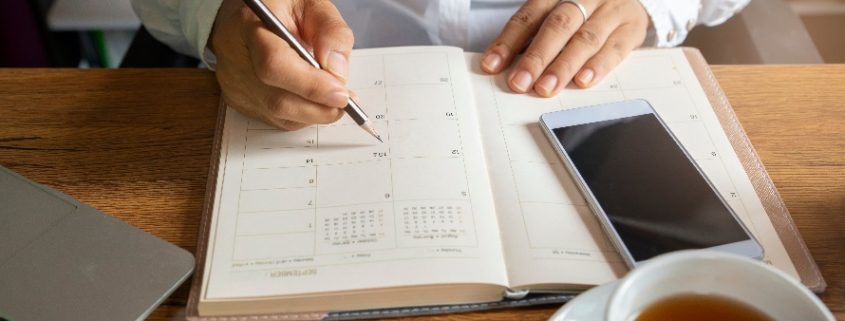 Calendário do Exame da OAB: fotografia com foco em uma pessoa marcando compromissos em uma agenda.