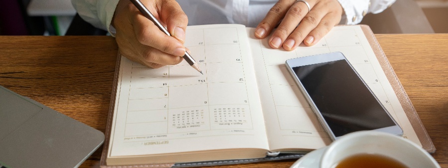 Calendário do Exame da OAB: fotografia com foco em uma pessoa marcando compromissos em uma agenda.