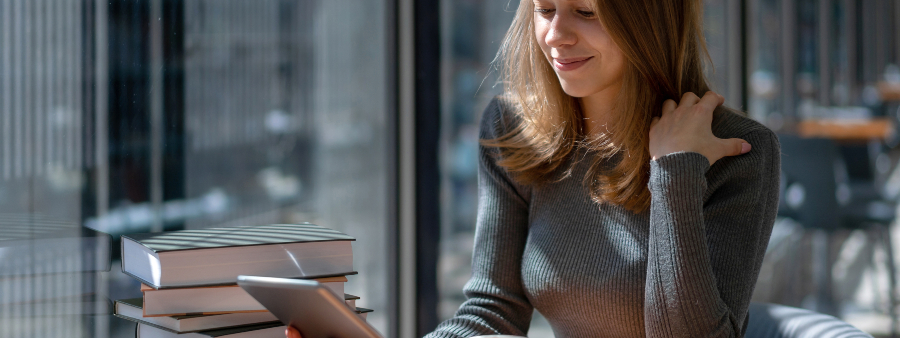 Leitura digital: fotografia de uma mulher lendo um livro em um tablet.