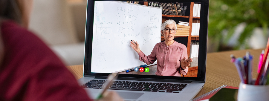 Tecnologias que vão transformar o ensino superior: fotografia com foco na tela de um notebook com uma professora dando aula online.