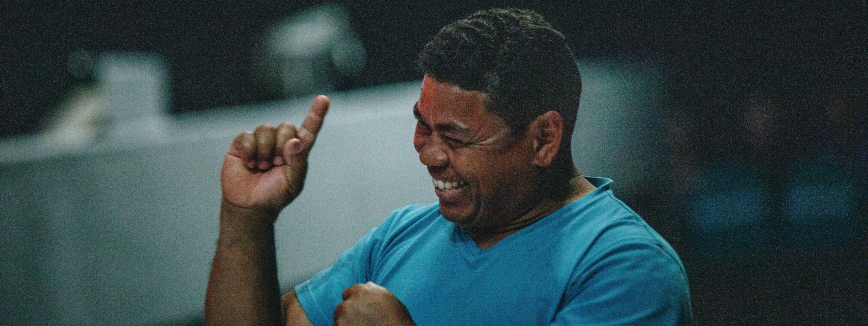 Acessibilidade na educação superior: fotografia de um homem sorrindo enquanto fala por meio da língua de sinais.
