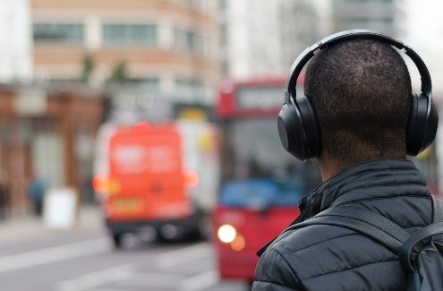 Podcast como ferramenta educacional: homem anda com fone de ouvido