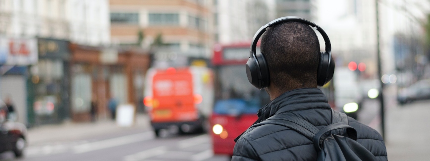 Podcast como ferramenta educacional: homem anda com fone de ouvido