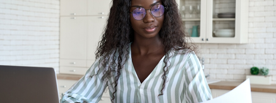 legal design: mulher negra usando óculos e analisando papelada