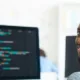 competência tecnológica: homem sorrindo em frente a computador
